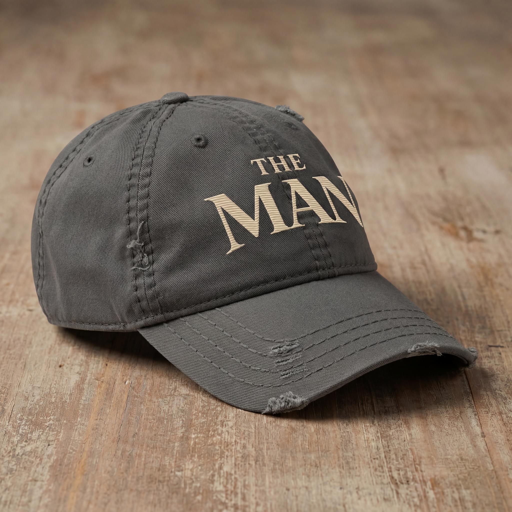 Charcoal THE MAN embroidered hat shown from a side angle.